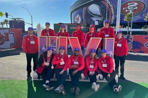 澳门线上赌博平台大学 students pose with the Super Bowl LVIII logo in front of Allegiant Stadium in Las Vegas.
